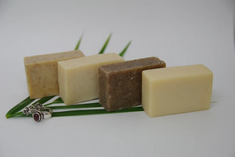 several bar of soaps sitting next to a green plant