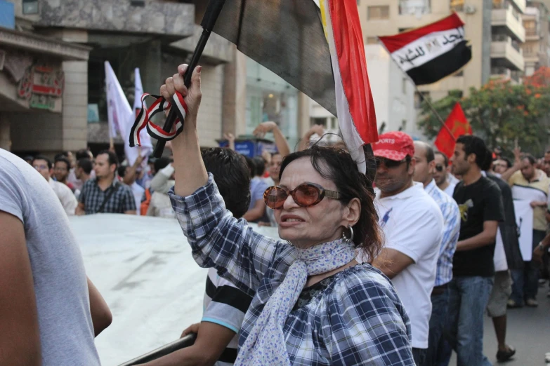 a woman wearing glasses holding a flag and walking