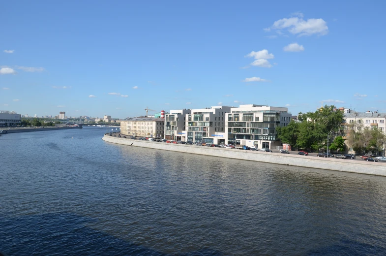 buildings line a waterway with trees lining both sides