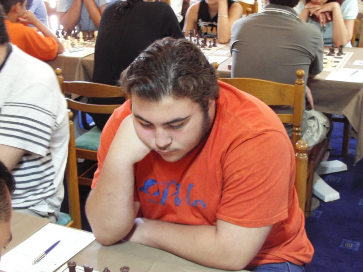 a young man who is sitting in front of a chess board