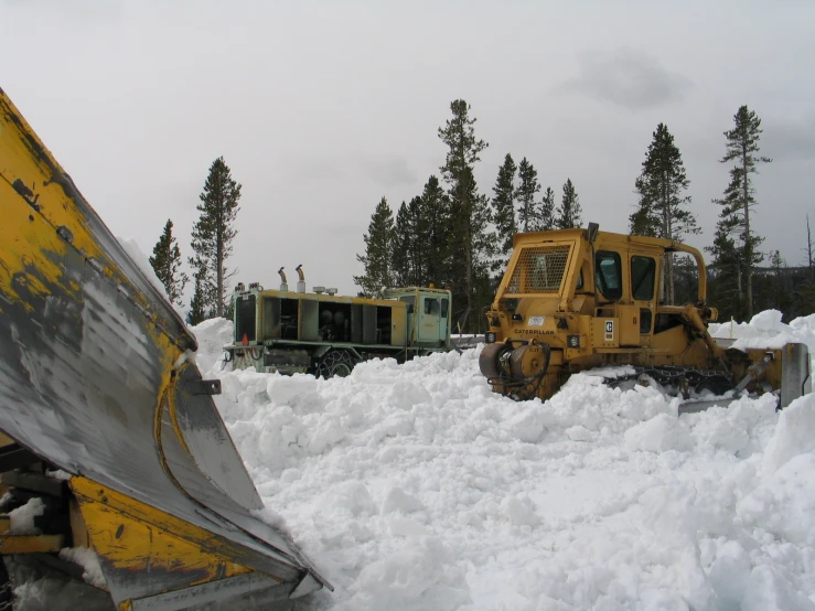 large snow piles in front of vehicles and trees