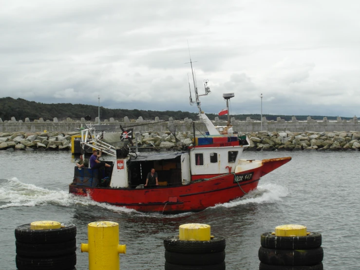 the boat is going through the water near the shore