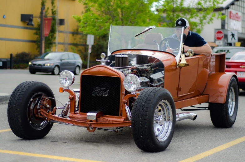 a man is sitting in an orange old - fashioned model t