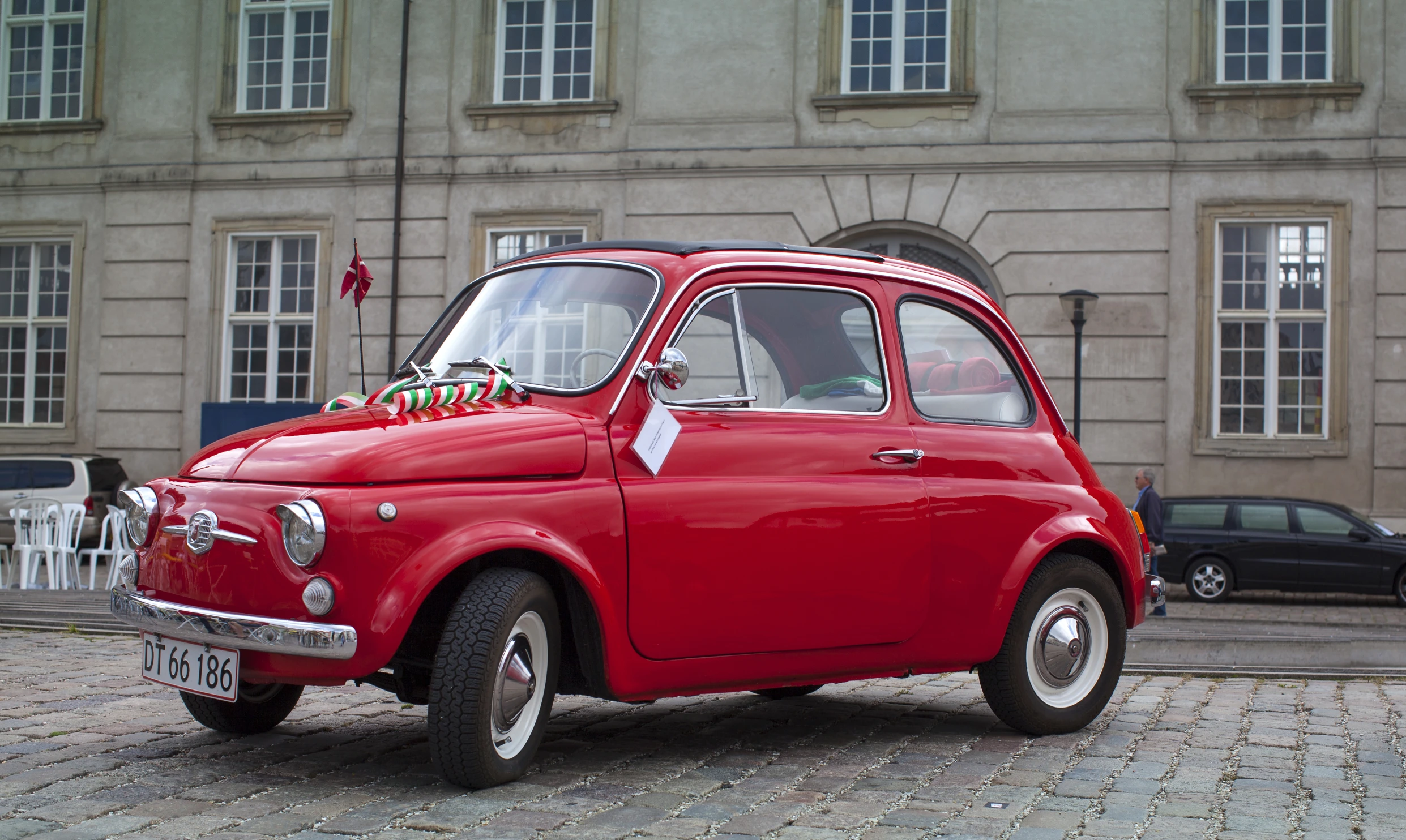 a small red car on a city street