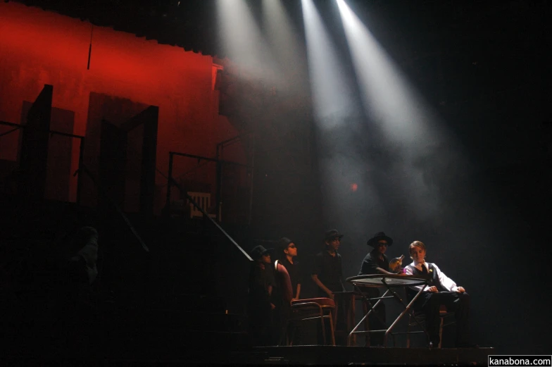 the cast of urine in an unsold show sits on stage in front of a set