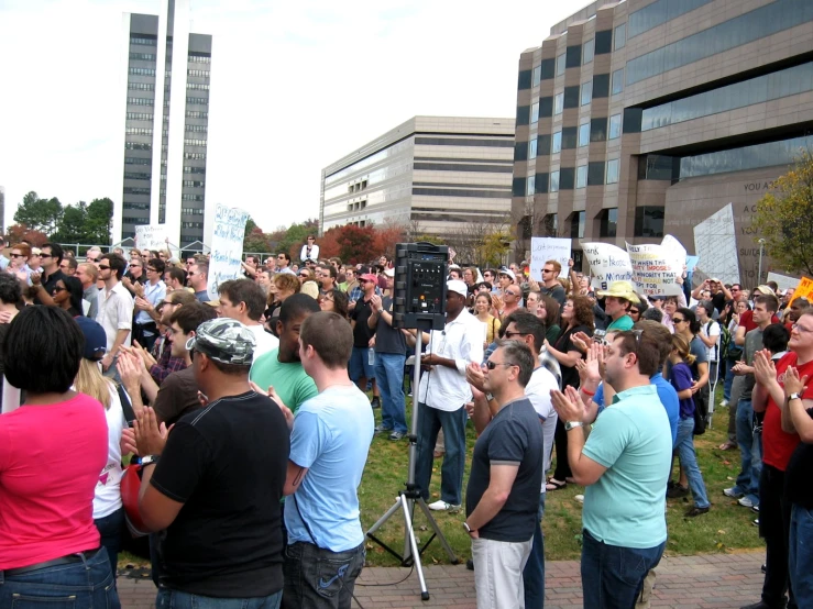 many people standing in front of a camera, in a protest