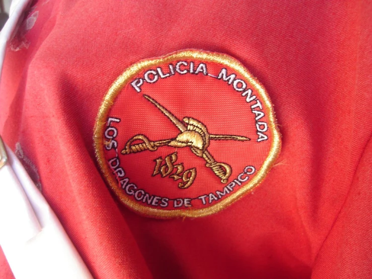 a polo shirt with an emblem in front of the pocket