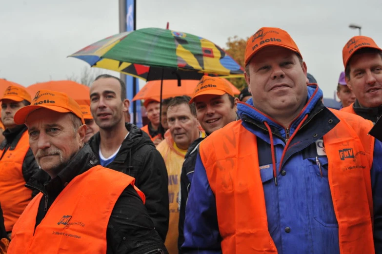 a group of men wearing orange safety jackets and orange hats