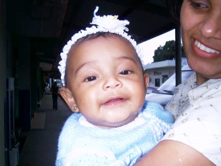 a baby with a blue shirt and white hairband