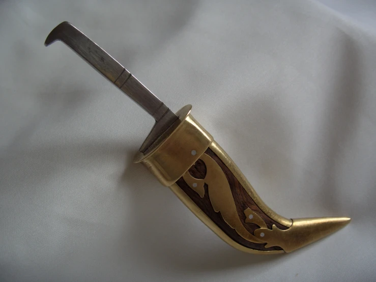 a gold colored knife with an intricate design