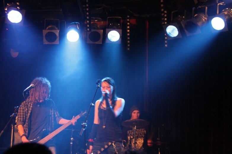 people are standing on the stage with lights around