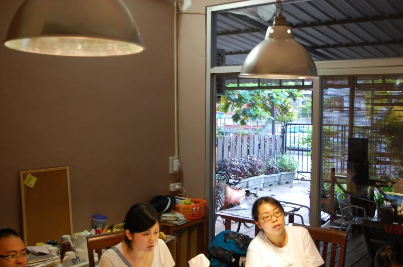 two women are sitting at the table with drinks