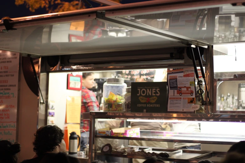 a person is standing near a small food stand