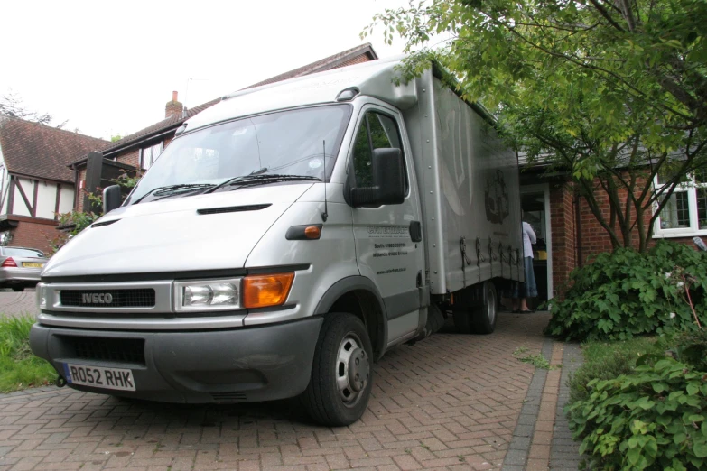 a silver truck is parked outside of a house