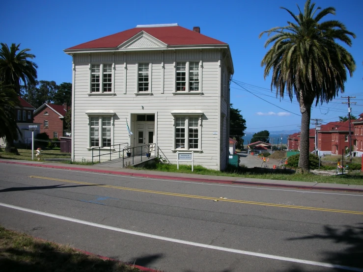 a small white house sitting on the side of a road