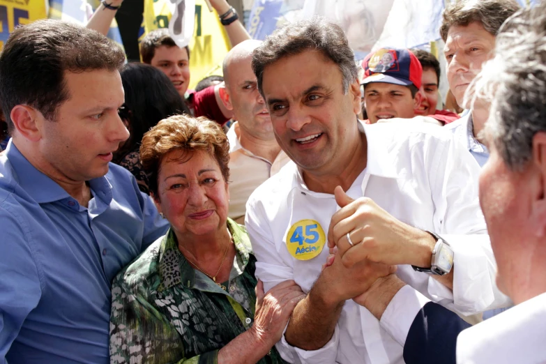 a man being held by his parents while he is surrounded by other people