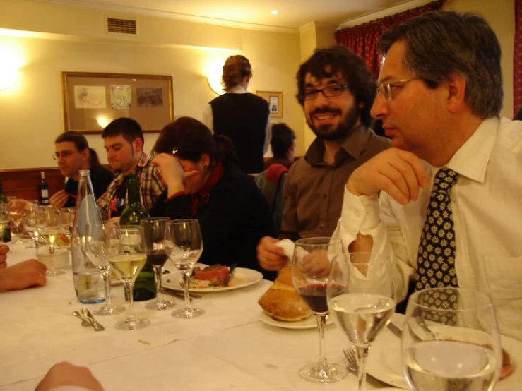 many people sitting at a long table sharing food