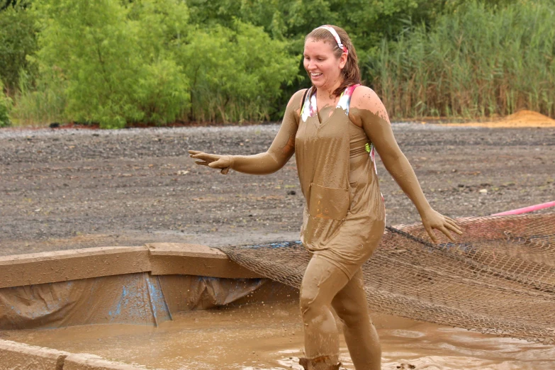 a woman wearing a mud suit and carrying a large net