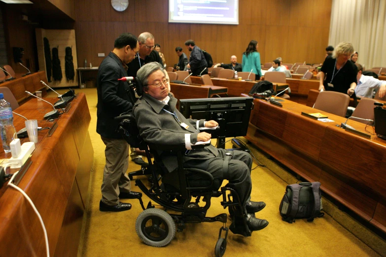 a man in a wheelchair is surrounded by people