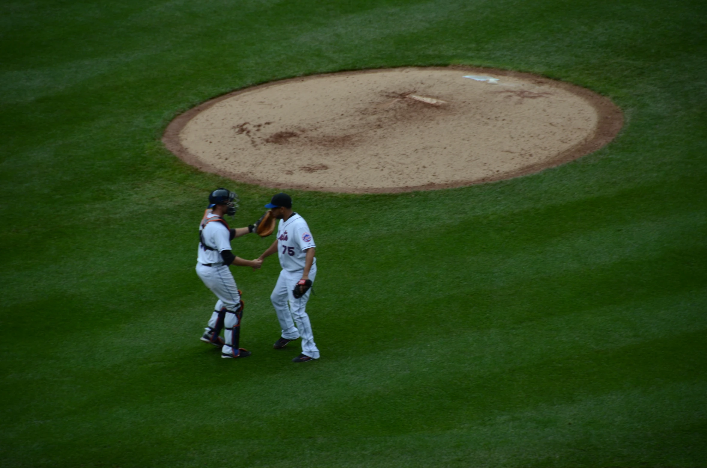 two baseball players shake hands after playing a game