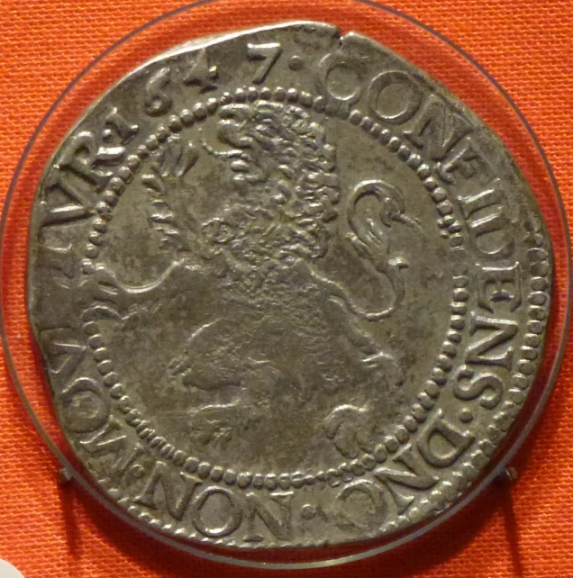 an antique coin is displayed on an orange background