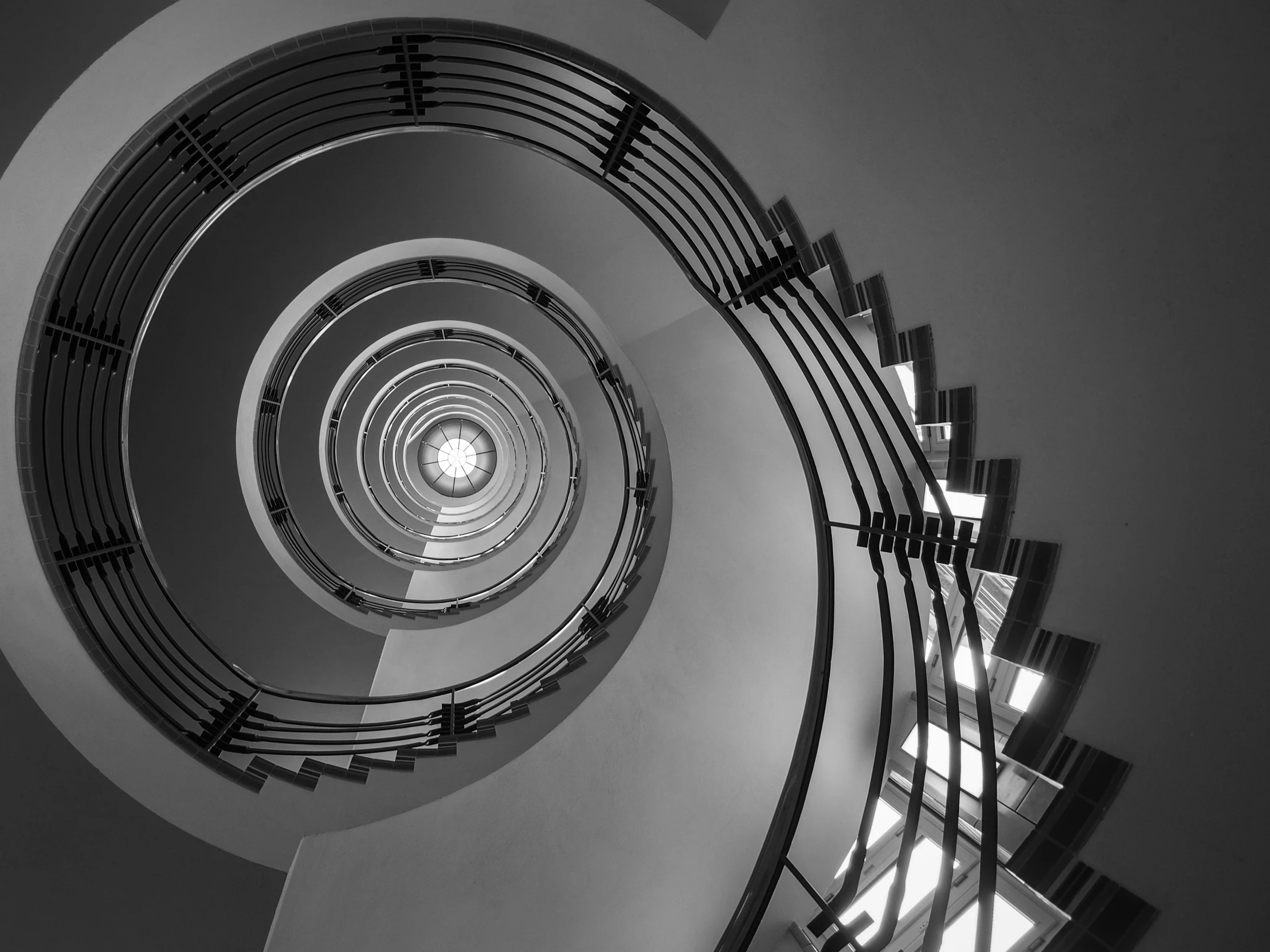 the ceiling of a spiral stairway in black and white