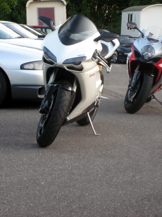 two motorcycles parked side by side in a parking lot