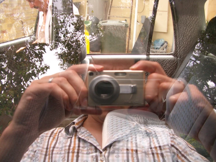 a man taking a po in a mirror while holding his camera