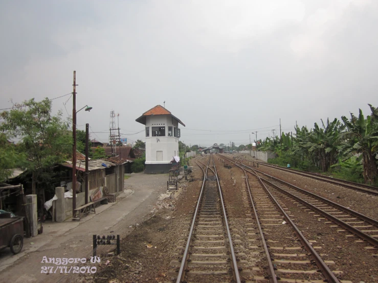 a tall white tower sitting on the side of train tracks