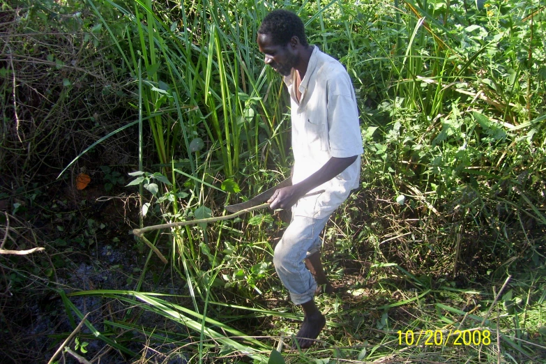 a man wearing white standing in tall grass