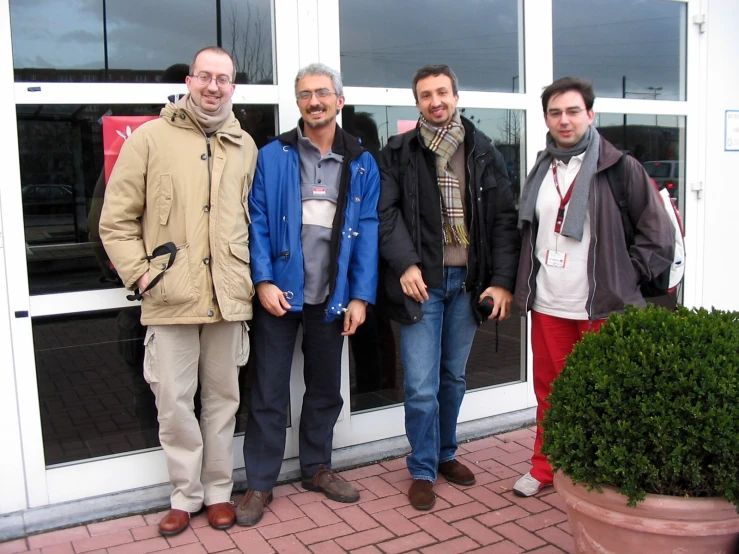 four men are standing outside on the patio