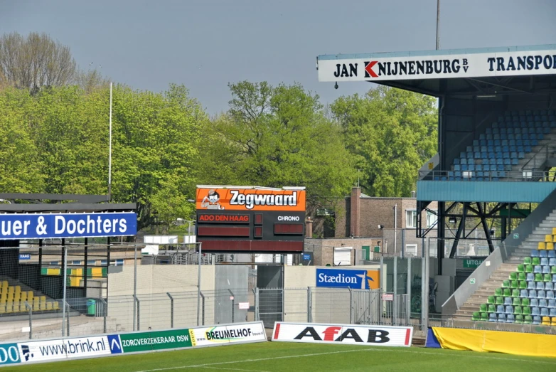 an empty soccer field sits in front of the bleachers