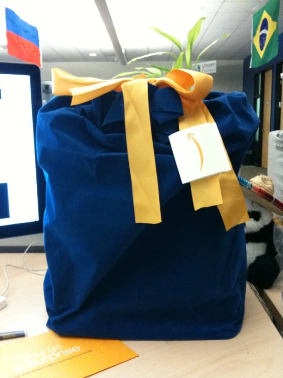 a bag sitting on a desk covered with a blue and yellow ribbon