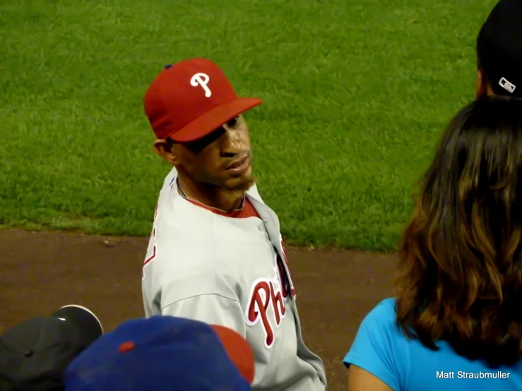 a man in a baseball uniform sitting on the base line