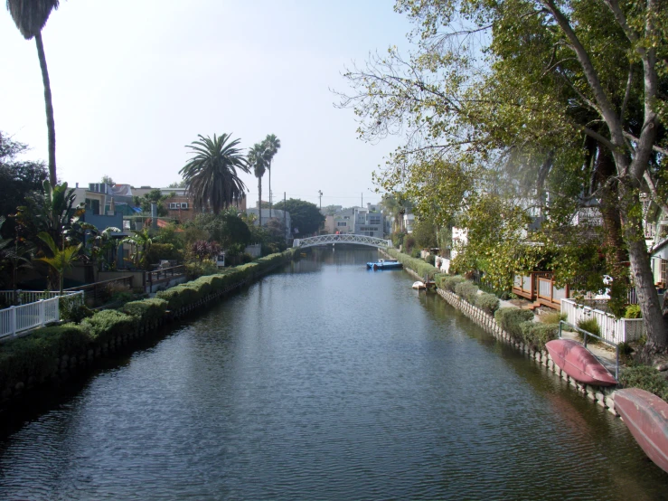 a long waterway with small boats is running through the area