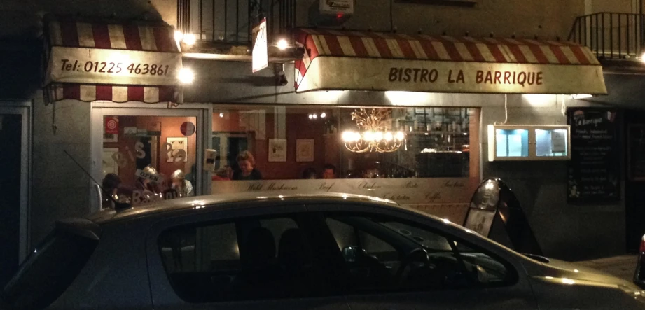 a restaurant with cars parked outside and the lights on