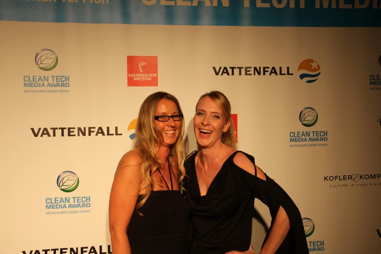 two women pose together on the red carpet for the event