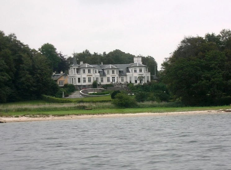 a large white building sitting on top of a lush green field