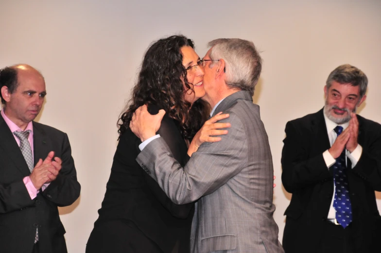 two men and one woman are kissing on a stage