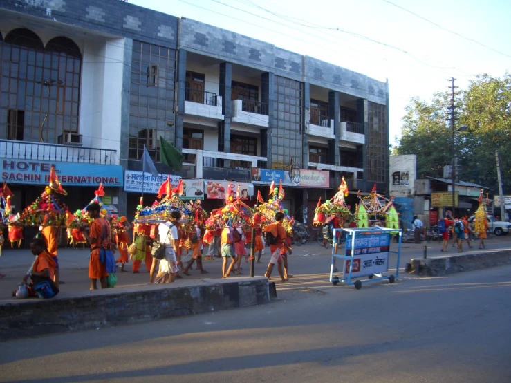 people in colorful dresses and headdress ride on a city street