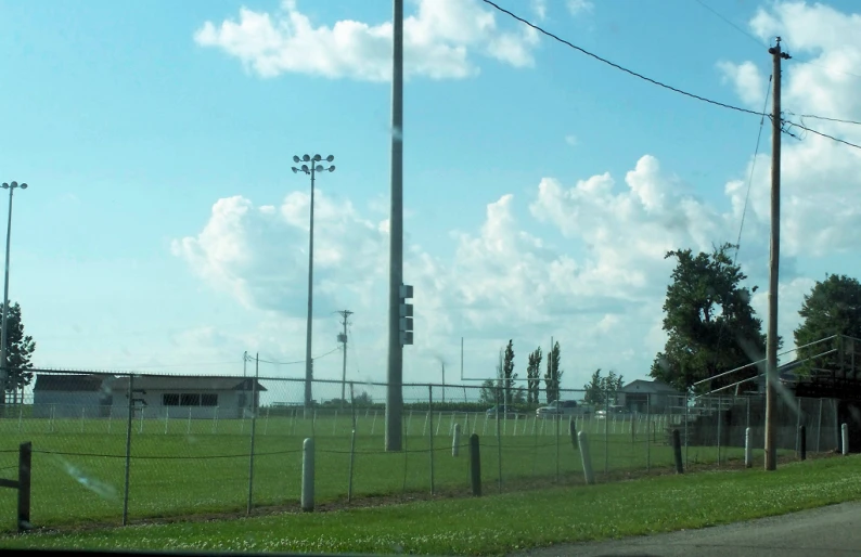 a field behind a fence with many lights on