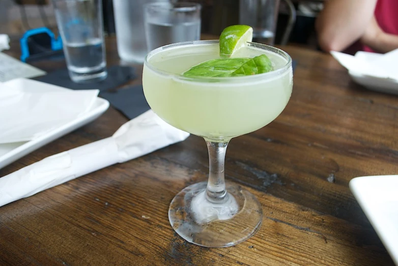 a margarita cocktail sitting on a wood table