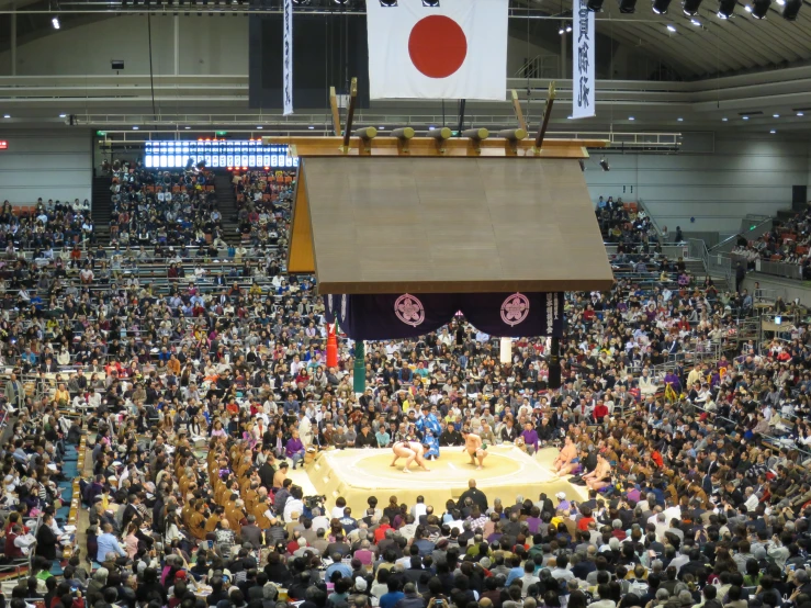 a big auditorium full of people and an oriental flag