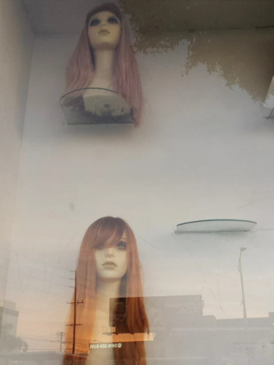 two women's mannequins are on display at the window of a fashion store