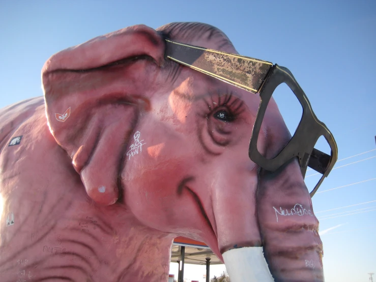 an elephant statue with eye glasses painted on it