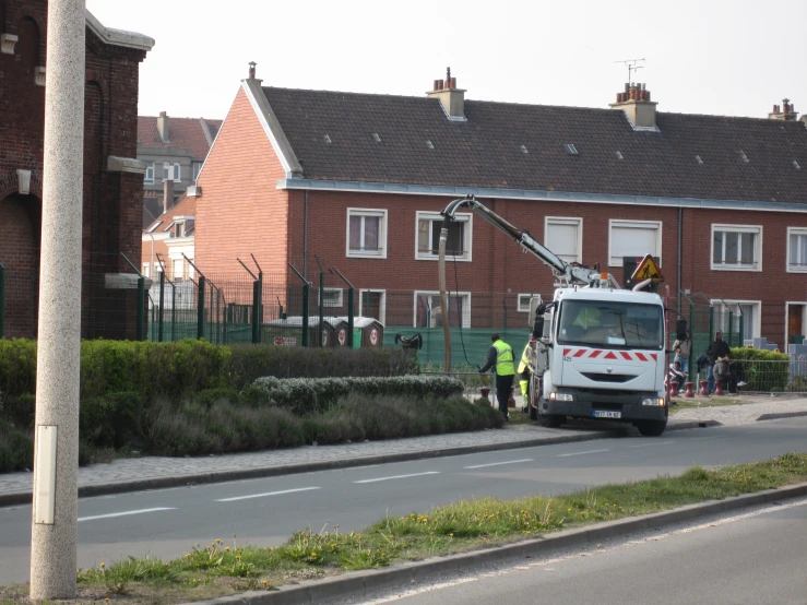 a truck with people looking on and a firetruck is near the house