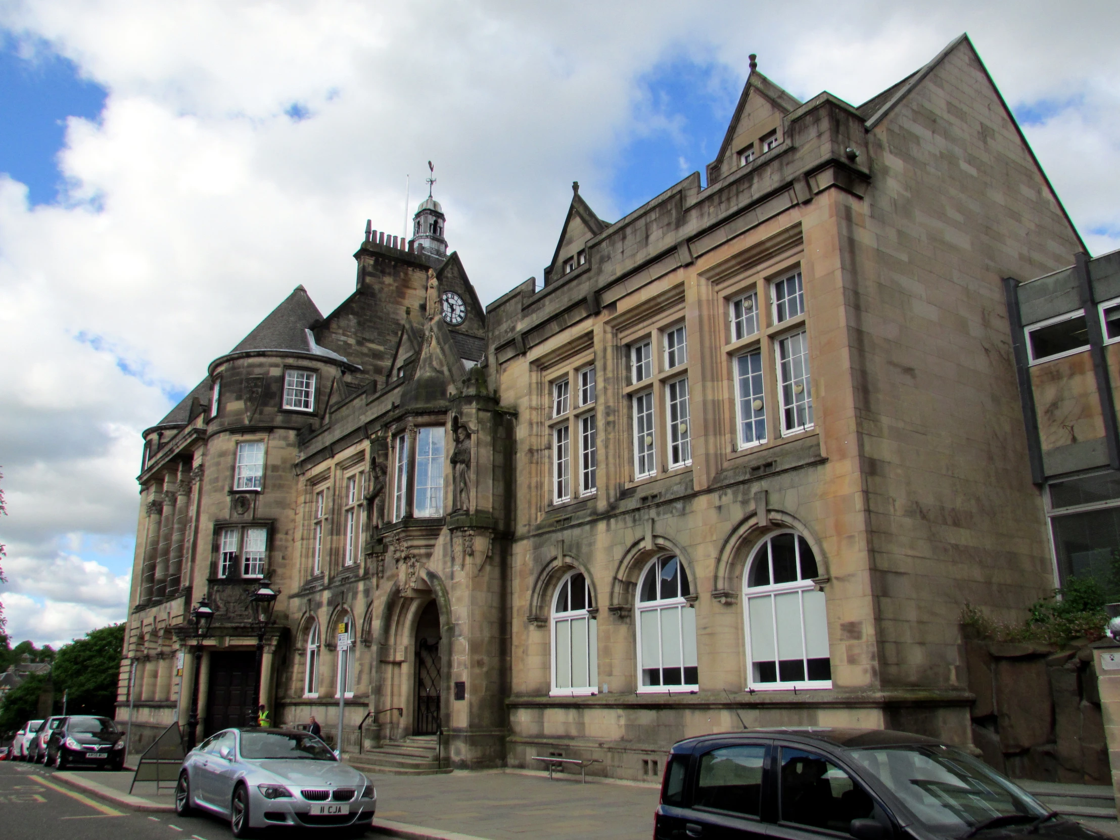 a large old building has a parking lot in front of it