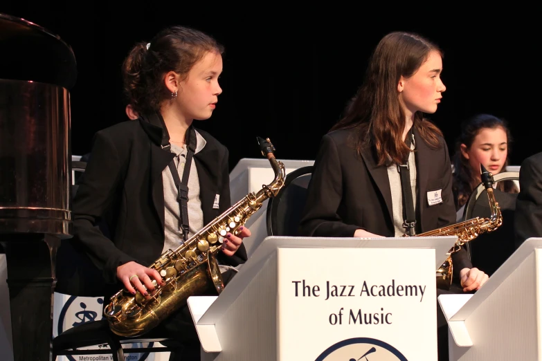 three s in suits play on saxophones