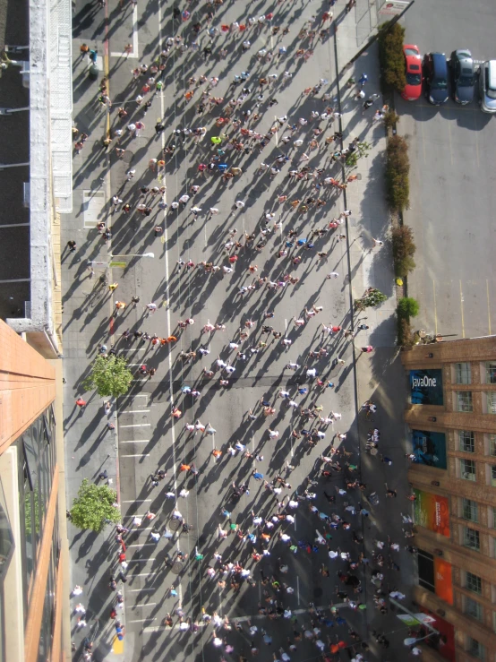 a lot of people walking on the street with buildings and cars