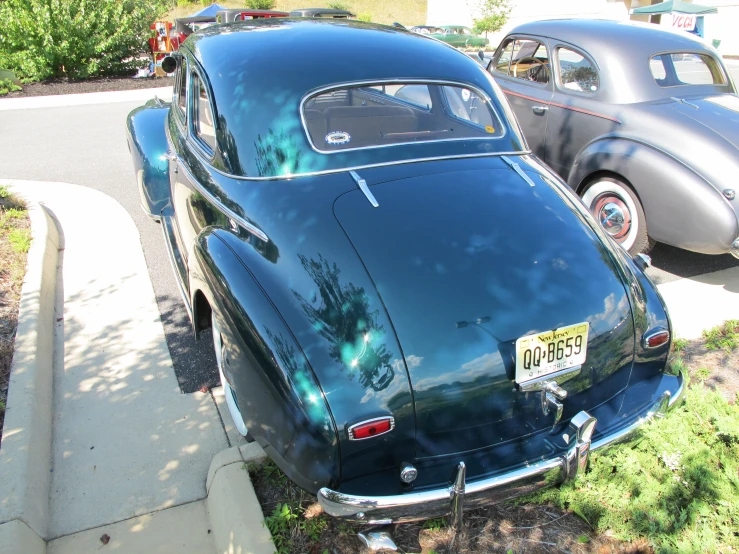 the back end of an old car sitting on the street